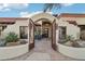 Inviting front entrance with arched gate, charming desert landscaping, and a warm, welcoming ambiance at 22402 N 84Th Pl, Scottsdale, AZ 85255