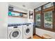 Functional laundry room with modern appliances, blue tile countertop, and ample natural light at 22402 N 84Th Pl, Scottsdale, AZ 85255