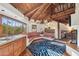 Inviting living room with wooden ceiling beams, a cozy seating area, and terracotta tile flooring at 22402 N 84Th Pl, Scottsdale, AZ 85255
