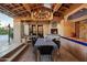 Inviting outdoor dining area with a fireplace, chandelier, and comfortable seating, perfect for entertaining guests at 22402 N 84Th Pl, Scottsdale, AZ 85255