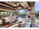 Inviting covered patio with comfortable seating, a fireplace, and views of the pool and backyard oasis at 22402 N 84Th Pl, Scottsdale, AZ 85255