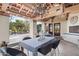 Covered patio featuring stone flooring, wooden beams, chandelier, and an outdoor dining area overlooking the pool at 22402 N 84Th Pl, Scottsdale, AZ 85255