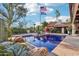 Inviting pool with blue tile reflecting the home, landscaping, and American and University of Arizona flags at 22402 N 84Th Pl, Scottsdale, AZ 85255