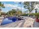 Backyard pool featuring blue tile, surrounded by mature trees and landscaping, with patio and lounge areas at 22402 N 84Th Pl, Scottsdale, AZ 85255