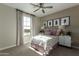 Bedroom with a ceiling fan, large window with curtains, and stylish artwork on the wall at 27629 N 176Th Dr, Surprise, AZ 85387