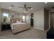 This bedroom boasts an upholstered bed frame, ceiling fan, and ensuite bathroom access at 27629 N 176Th Dr, Surprise, AZ 85387