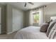 Bright bedroom featuring a window, white closet, and white bedding at 27629 N 176Th Dr, Surprise, AZ 85387