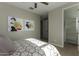Bright bedroom with a ceiling fan, artwork, and an open closet design for ample storage at 27629 N 176Th Dr, Surprise, AZ 85387