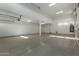 Spacious garage with epoxy flooring, white walls, and overhead lighting at 27629 N 176Th Dr, Surprise, AZ 85387