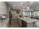 Open kitchen with stainless appliances, white countertops, and an island, flowing into the living area at 27629 N 176Th Dr, Surprise, AZ 85387