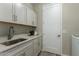 Laundry room featuring a stainless steel sink, ample storage cabinets, and modern countertops at 27629 N 176Th Dr, Surprise, AZ 85387