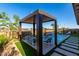 Backyard pool with pergola-covered seating area, waterfall feature and decorative walkway at 27629 N 176Th Dr, Surprise, AZ 85387