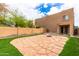 Private backyard featuring a stone patio area, artificial grass, and a brick perimeter at 2912 E Eberle Ln, Phoenix, AZ 85032