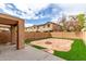 Backyard features stone patio, artificial grass, and brick wall, creating an outdoor space at 2912 E Eberle Ln, Phoenix, AZ 85032