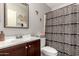Clean bathroom with dark wood vanity, patterned shower curtain and a mirror at 2912 E Eberle Ln, Phoenix, AZ 85032