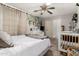 Bright bedroom showcasing a crib, decor, ceiling fan, and closet access at 2912 E Eberle Ln, Phoenix, AZ 85032