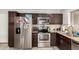 Well lit kitchen with stainless steel refrigerator, oven, microwave, and granite countertops at 2912 E Eberle Ln, Phoenix, AZ 85032