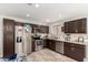 Wide angle of kitchen featuring granite countertops, stainless appliances, and dark cabinets at 2912 E Eberle Ln, Phoenix, AZ 85032