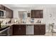 Charming kitchen with brown cabinets, granite countertops and stainless steel dishwasher at 2912 E Eberle Ln, Phoenix, AZ 85032