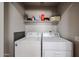 Bright laundry room features modern washer and dryer and ample storage shelf at 2912 E Eberle Ln, Phoenix, AZ 85032