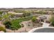 An aerial view of the landscaped front yard and circle drive with a lush green parkway in the distance at 29854 N 132Nd Dr, Peoria, AZ 85383