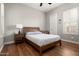 Cozy bedroom with hardwood floors, full bed, side tables and bright, natural lighting through multiple windows at 29854 N 132Nd Dr, Peoria, AZ 85383