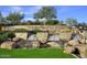 Beautiful Trilogy entrance featuring a stone wall with a cascading waterfall feature and lush landscaping at 29854 N 132Nd Dr, Peoria, AZ 85383