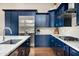 Stylish kitchen featuring dark blue cabinets, stainless steel appliances, and marble countertops at 29854 N 132Nd Dr, Peoria, AZ 85383