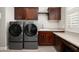 Laundry room features front loading washer and dryer, sink, and wood cabinets at 29854 N 132Nd Dr, Peoria, AZ 85383
