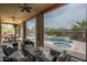 Covered outdoor living room has comfortable seating with views of pool and backyard at 29854 N 132Nd Dr, Peoria, AZ 85383