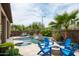 Backyard pool and spa are surrounded by travertine patio and seating surrounding a gas firepit at 29854 N 132Nd Dr, Peoria, AZ 85383
