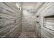 Luxurious shower with travertine walls, mosaic floor, rainfall shower head, and recessed niche for bath accessories at 29854 N 132Nd Dr, Peoria, AZ 85383