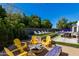 Beautiful backyard with lush greenery, yellow Adirondack chairs, and outdoor dining area at 3117 E Campbell Ave, Phoenix, AZ 85016