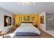 Bright bedroom featuring a yellow accent wall, king bed, and contemporary decor at 3117 E Campbell Ave, Phoenix, AZ 85016