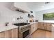 Modern kitchen with white countertops, stainless steel appliances, and stylish backsplash at 3117 E Campbell Ave, Phoenix, AZ 85016