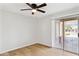 Bright bedroom featuring wood floors, ceiling fan and a sliding door to the outside at 3326 E Calypso Ave, Mesa, AZ 85204