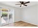 Sunlit bedroom showcasing wood flooring, ceiling fan and sliding glass door to patio at 3326 E Calypso Ave, Mesa, AZ 85204