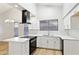 Modern kitchen with white cabinets, stainless sink, black appliances, and bright countertop at 3326 E Calypso Ave, Mesa, AZ 85204