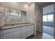 Well-lit bathroom with a double sink vanity, granite countertops and access to the bedroom at 39970 W Bravo Dr, Maricopa, AZ 85138