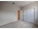 Neutral bedroom with carpet, closet, and an open door, providing a view into the house at 39970 W Bravo Dr, Maricopa, AZ 85138