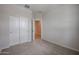 Neutral bedroom with carpet, closet, and an open door, providing a view into the house at 39970 W Bravo Dr, Maricopa, AZ 85138