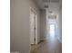 Bright hallway featuring tile flooring and neutral paint, leading to various rooms in the home at 39970 W Bravo Dr, Maricopa, AZ 85138