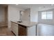 Granite island in open kitchen with stainless dishwasher and tile floors at 39970 W Bravo Dr, Maricopa, AZ 85138