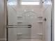 Shower features bright, clean white shower surround, window, and convenient built-in shelves at 39970 W Bravo Dr, Maricopa, AZ 85138