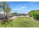 Expansive backyard with lush lawn, swing set, pool, and outdoor kitchen area at 4115 S 75Th Dr, Phoenix, AZ 85043