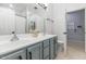 Bathroom with double sinks, white countertops, gray cabinets, and a view of the shower and toilet area at 4115 S 75Th Dr, Phoenix, AZ 85043