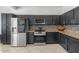 Well-appointed kitchen featuring dark cabinetry, granite countertops, and stainless steel appliances at 4115 S 75Th Dr, Phoenix, AZ 85043