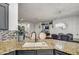 Close-up on granite countertops, sink, and dark cabinetry, with a view into the dining area at 4115 S 75Th Dr, Phoenix, AZ 85043