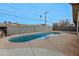 An in-ground backyard pool surrounded by desert landscaping and a concrete block fence at 4238 W Krall St, Phoenix, AZ 85019