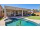Inviting backyard oasis featuring a sparkling pool, covered patio, and putting green perfect for outdoor entertaining and relaxation at 45140 W Zion Rd, Maricopa, AZ 85139